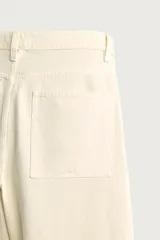 Jeans straight fit color beige claro, con tiro medio, pernera recta de cinco bolsillos y cierre frontal con cremallera y botón.