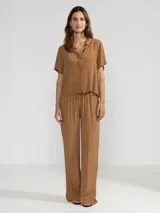 Pantalón palazzo color marrón, de corte recto y cintura elastizada.