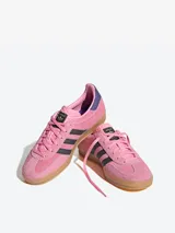 Championes Adidas Gazelle Indoor color rosa con las tres tiras laterales en negro y detalles en violeta.