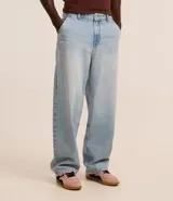 Pantalón baggy de jean azul, con bolsillos delanteros tipo cuchillo y bolsillos traseros.