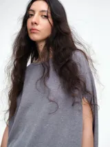 Top de silueta amplia y corte cuadrado, con mangas cortas caídas, cuello redondo y acabado con micro lentejuelas sutiles.