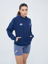 Canguro deportivo Umbro del Club Nacional de Football, color bordó, con capucha ajustable con cordón, bolsillo tipo canguro y costuras visibles en contraste. Presenta el logo de Umbro y el escudo del club bordados en el frente.