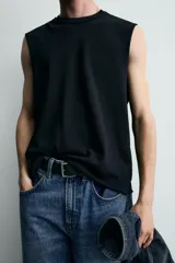 Camiseta tank de punto de algodón, color negro, de corte relaxed fit con cuello redondo, manga sisa y acabados irregulares.