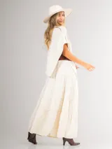 Poncho de corte holgado y diseño minimalista, confeccionado en tejido liviano de color beige, con cuello redondo y caída fluida.