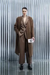 Abrigo midi marrón con silueta relajada y textura suave, doble botonadura y bolsillos invisibles.