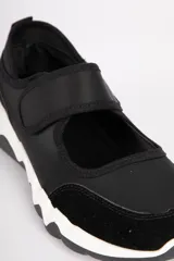 Zapatillas tipo guillerminas negras con recortes en símil cuero y tela, con velcro y pespuntes a tono.