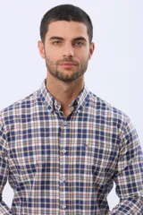 Camisa de manga larga con cuello abotonado y cierre frontal con botones. Presenta un diseño de estampado a cuadros en tonos azul, blanco y naranja.