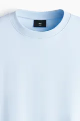 Remera celeste de corte oversized y diseño boxy en punto liviano de algodón, con hombros caídos y cuello redondo ribeteado acanalado.