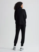 Campera negra de corte holgado con cierre bidireccional, cuello alto y bolsillos frontales.