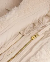 Bolso tote de sherpa color crema, con asas de mano y correa bandolera ajustable. Cuenta con cierre de cremallera y bolsillos internos.