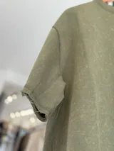 Remerón de corte oversize en tejido rústico con efecto gastado, cuello redondo y mangas cortas.