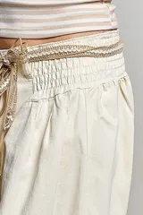 Pantalón ancho de jean claro, confeccionado en algodón, con cintura fruncida y puños elásticos.