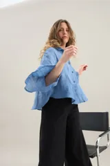 Camisa de silueta amplia y fluida color celeste, con cuello camisero clásico y mangas cortas amplias.