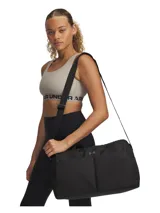 Bolso deportivo tipo duffle color negro, con compartimento principal con cierre, bolsillos delanteros abiertos y correa ajustable para el hombro. Presenta el logo de la marca en el frente.