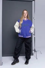 Pantalón parachute negro de tela sintética con frunces en las piernas y cintura elástica.