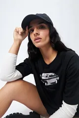 Remera negra cropped de manga corta con mangas ranglan, y estampado frontal de un auto antiguo con el texto "Vintage Gems".