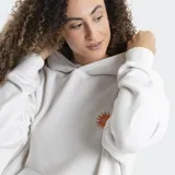 Canguro con capucha color blanco, de corte holgado y diseño básico. Presenta un bolsillo frontal tipo canguro y un pequeño estampado de sol con el logo de la marca en el pecho.