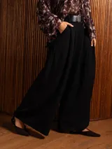 Pantalon tipo palazzo de corte amplio y tiro alto, con pinzas frontales, bolsillos laterales y cintura elástica.