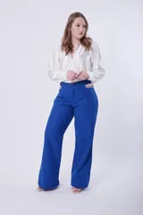 Pantalón palazo azul con detalle de cadena dorada en la cintura.