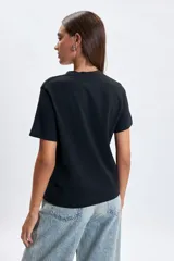Remera de manga corta color negro con estampa frontal en color blanco con el texto Viena Life in Motion.
