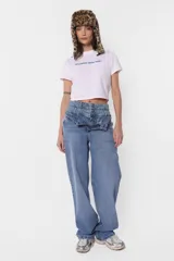 Remera blanca de jersey corte baby tee con cuello alto de ribb complemento. Estampa en delantero con la frase "30 million dolar babe" en color azul.