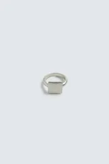 Anillo sello metálico con baño de plata y diseño cuadrado minimalista.