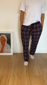 Pantalón de hombre confeccionado en franela a cuadros grises y marrones, con elástico en la cintura y dos bolsillos laterales.