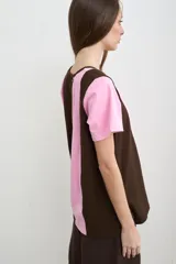 Remera de manga corta con escote en V, de diseño bicolor en marrón y rosado a rayas verticales.