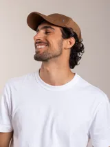 Gorra de pana color camel con visera curva y logo bordado en el lateral.