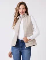 Chaleco capitoneado de diseño clásico con cuello alto reforzado y cierre frontal completo. Presenta bolsillos laterales amplios y un forro interior de símil piel para mayor calidez.