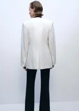 Chaqueta estructurada de corte recto y cuello de pico sin cierre. Presenta manga larga con aberturas en los puños, dos bolsillos de ribete laterales y una abertura posterior en el bajo. Incluye forro interior.