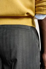 Pantalón de vestir gris con diseño de rayas sutiles, de corte relaxed fit, con pinzas delanteras y trabillas para cinturón.