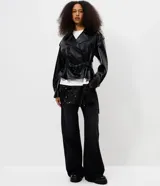 Campera tipo trench coat en PU color negro, de manga larga, con solapa amplia, hombreras decorativas y cinturón ajustable con hebilla en la cintura.