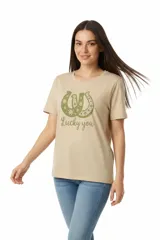 Remera de algodón color beige con cuello redondo y mangas cortas. Presenta un estampado frontal en color verde que incluye dos herraduras decoradas con flores y la frase 'Lucky you'.