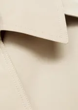 Chaqueta crop de doble botonadura color beige, con cuello pico con solapa, mangas largas y dos bolsillos laterales.