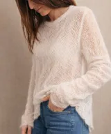 Sweater de punto calado confeccionado en 100% mohair italiano, con cuello redondo y mangas largas. Presenta una textura aireada y delicada con un diseño etéreo y sofisticado.