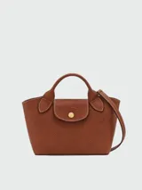 Cartera tipo tote en tamaño extra pequeño, confeccionada en cuero liso color verde oliva. Presenta una estructura rígida, doble asa corta superior y cierre de solapa con botón a presión metálico grabado con el logo de la marca.