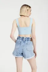 Short de jean celeste con cintura elastizada, detalle de botones y estampado de lunares blancos.