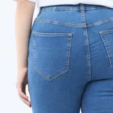 Pantalón de jean estilo skinny, de tiro muy alto con cierre frontal de botones expuestos. Presenta un lavado azul clásico y ajuste ceñido en las piernas.