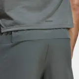 Short deportivo Adidas Designed For Training de color gris, con cintura elástica, cordón ajustable y bolsillos frontales con cierre. Cuenta con el logo de la marca en una de las piernas y aberturas laterales en el dobladillo.