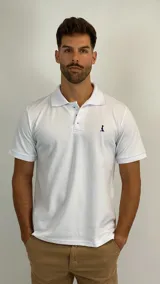 Chomba de piqué color blanco, de manga corta, con cuello clásico y cierre frontal de tres botones. Presenta un pequeño logo bordado en el pecho.