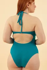 Malla entera negra con escote halter, aberturas en el abdomen y espalda descubierta.