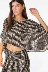 Blusa de lino italiano color blanco, con diseño holgado, escote asimétrico estilo off-shoulder y mangas cortas amplias.