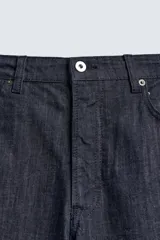 Jeans de corte slim fit en color azul oscuro, con diseño de cinco bolsillos, cierre frontal con cremallera y botón, y tejido ligeramente elástico.