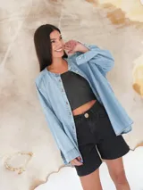 Camisa de denim liviano en tono azul claro, con cuello mao, cierre frontal con botones de nácar y mangas largas con corte holgado.