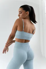 Top deportivo celeste con breteles finos regulables y espalda deportiva.