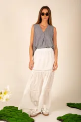 Falda larga blanca de corte amplio, con cintura elastizada y detalle de puntilla en el ruedo.