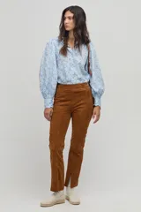 Camisa celeste con estampado floral en blanco, de corte clásico, cuello camisero y mangas largas abullonadas.