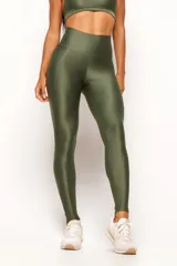 Calza deportiva de tiro alto en color verde militar, confeccionada en tejido técnico con acabado satinado. Presenta un diseño anatómico que se ajusta al cuerpo y cuenta con un bolsillo interno.