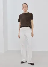 Remera marrón de corte recto, con cuello redondo, manga corta y detalle de bolsillo con bordado en el pecho.